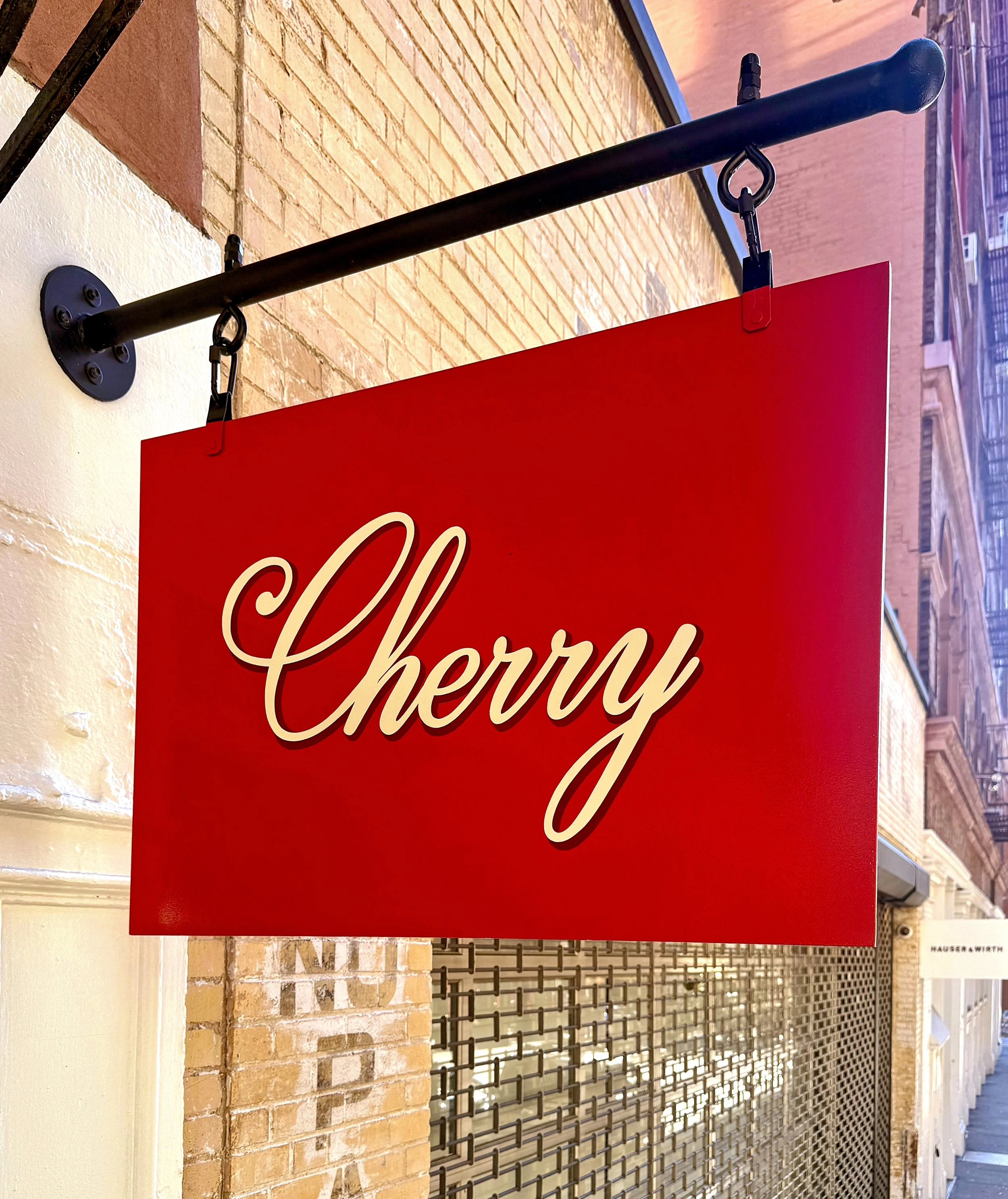 Hand painted hanging sign for Cherry brand's NYC storefront