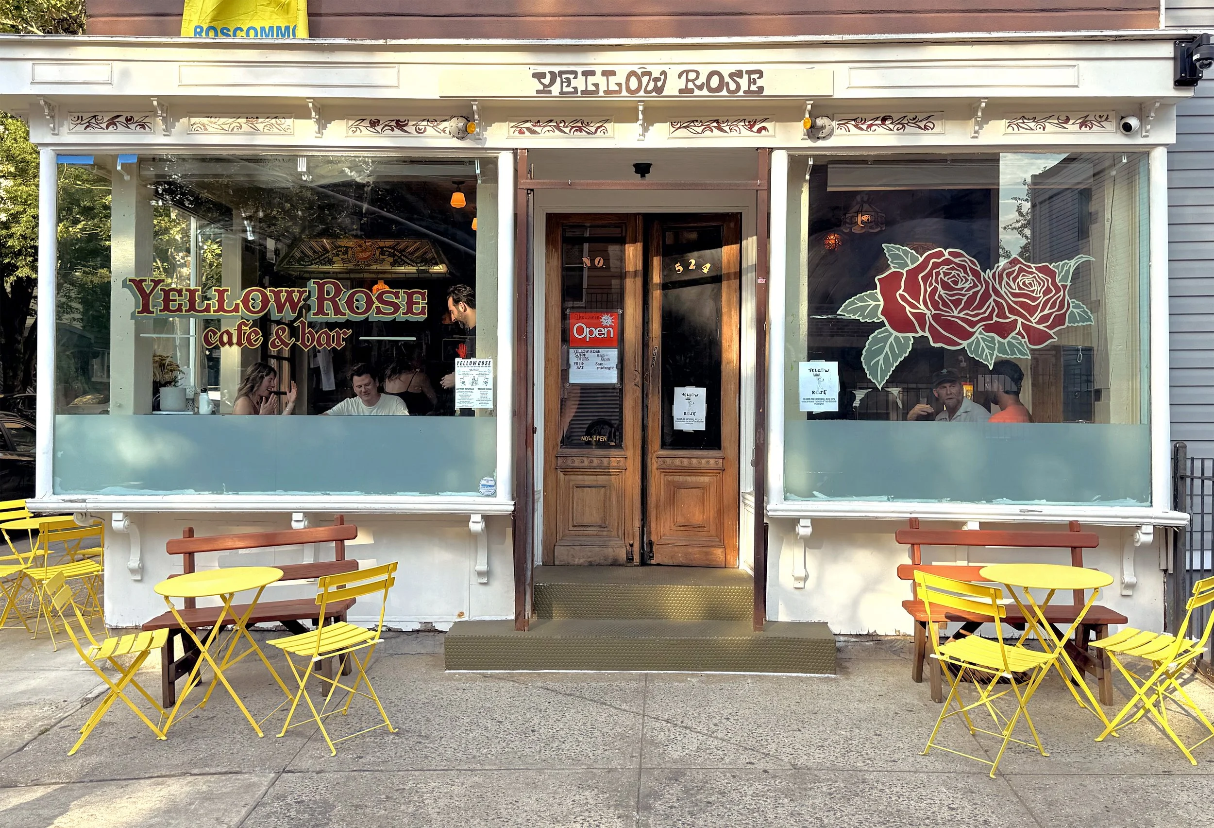 Hand painted signs on storefront windows for Yellow Rose in Brooklyn, NY