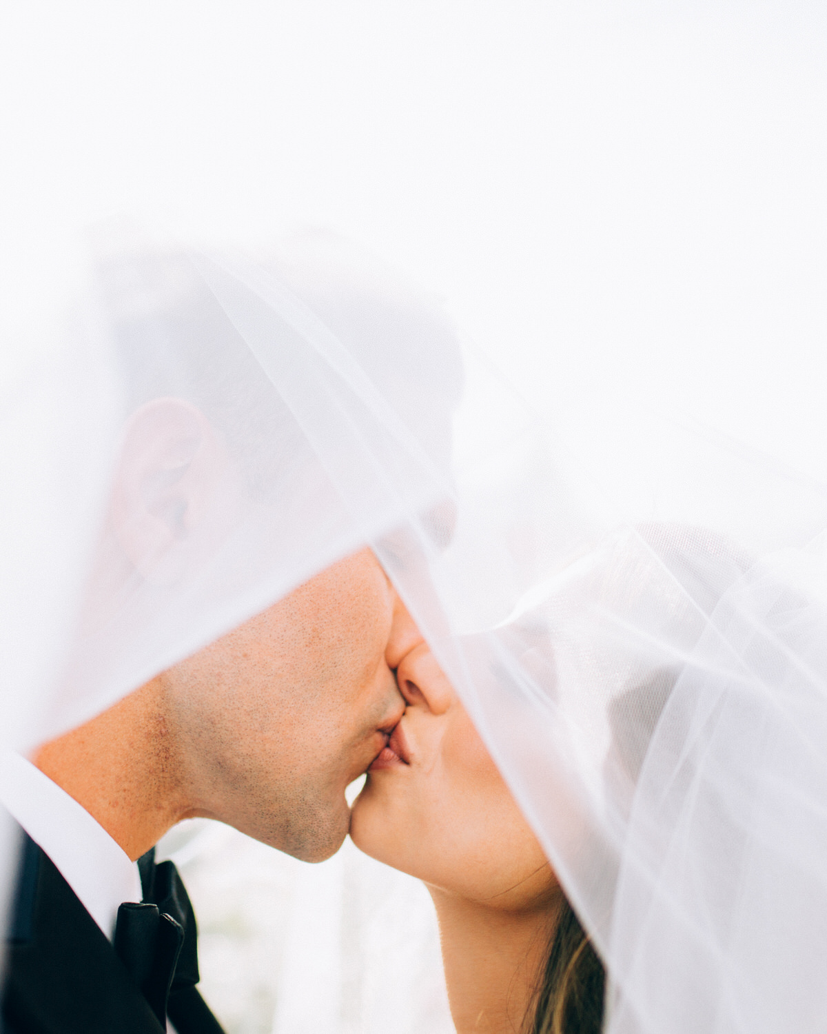 Bride and Groom Kissing under veil Armature Works Tampa