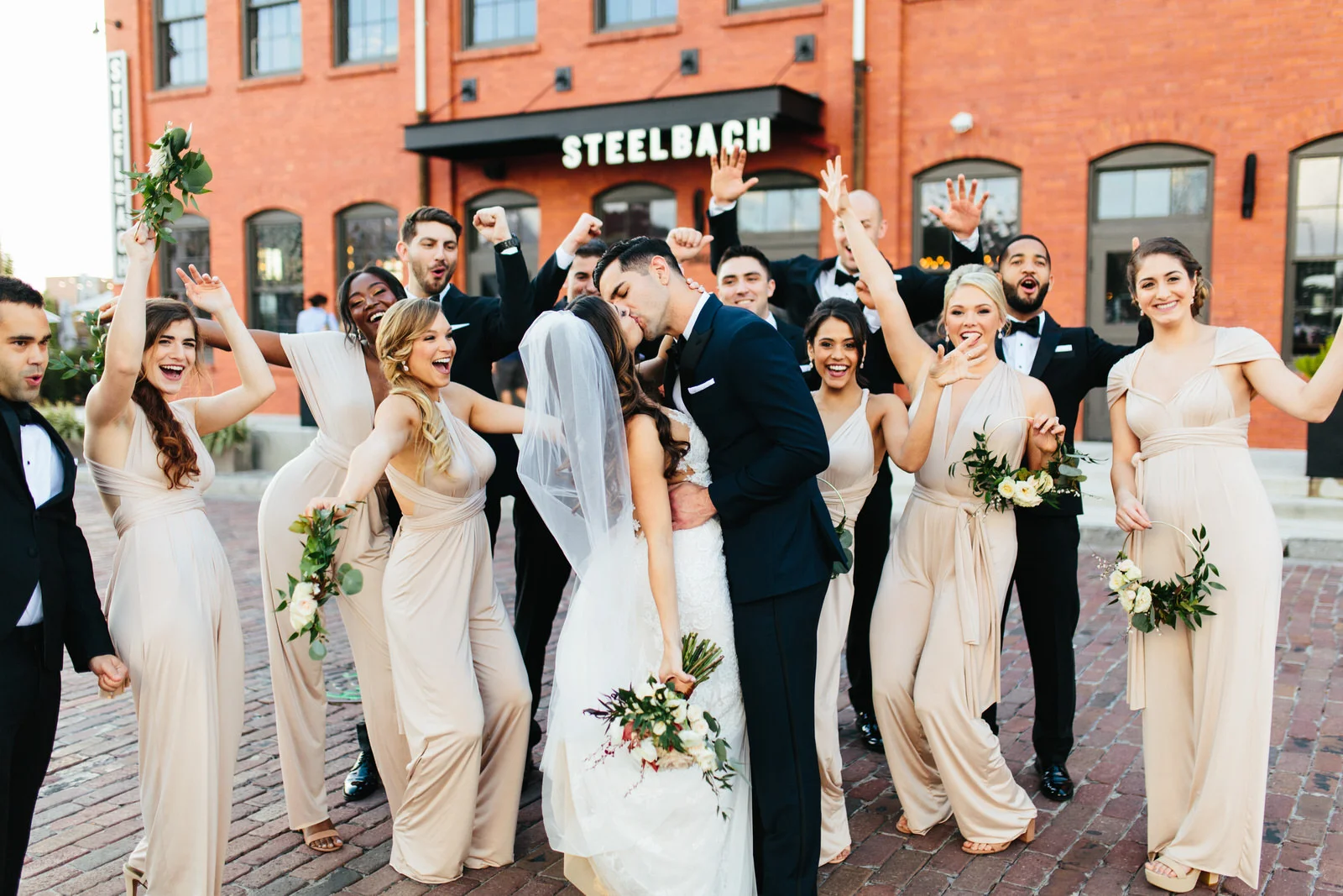 Bridal Party Cheering Bride and Groom Kiss