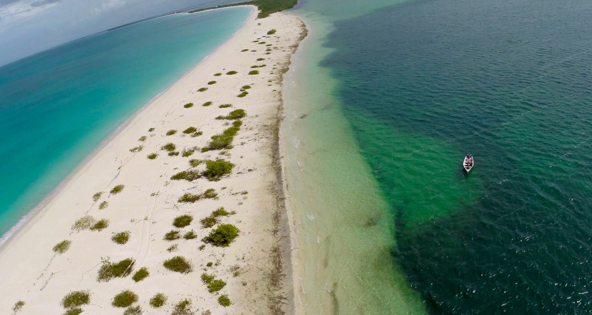 Sandbar separating the Caribbean sea and the Codrington Lagoon. This sandbar was broken through during Hurricane Luis in 1995 - Quadcopter Still, Tom Miller (that's us in the boat, BTW!)