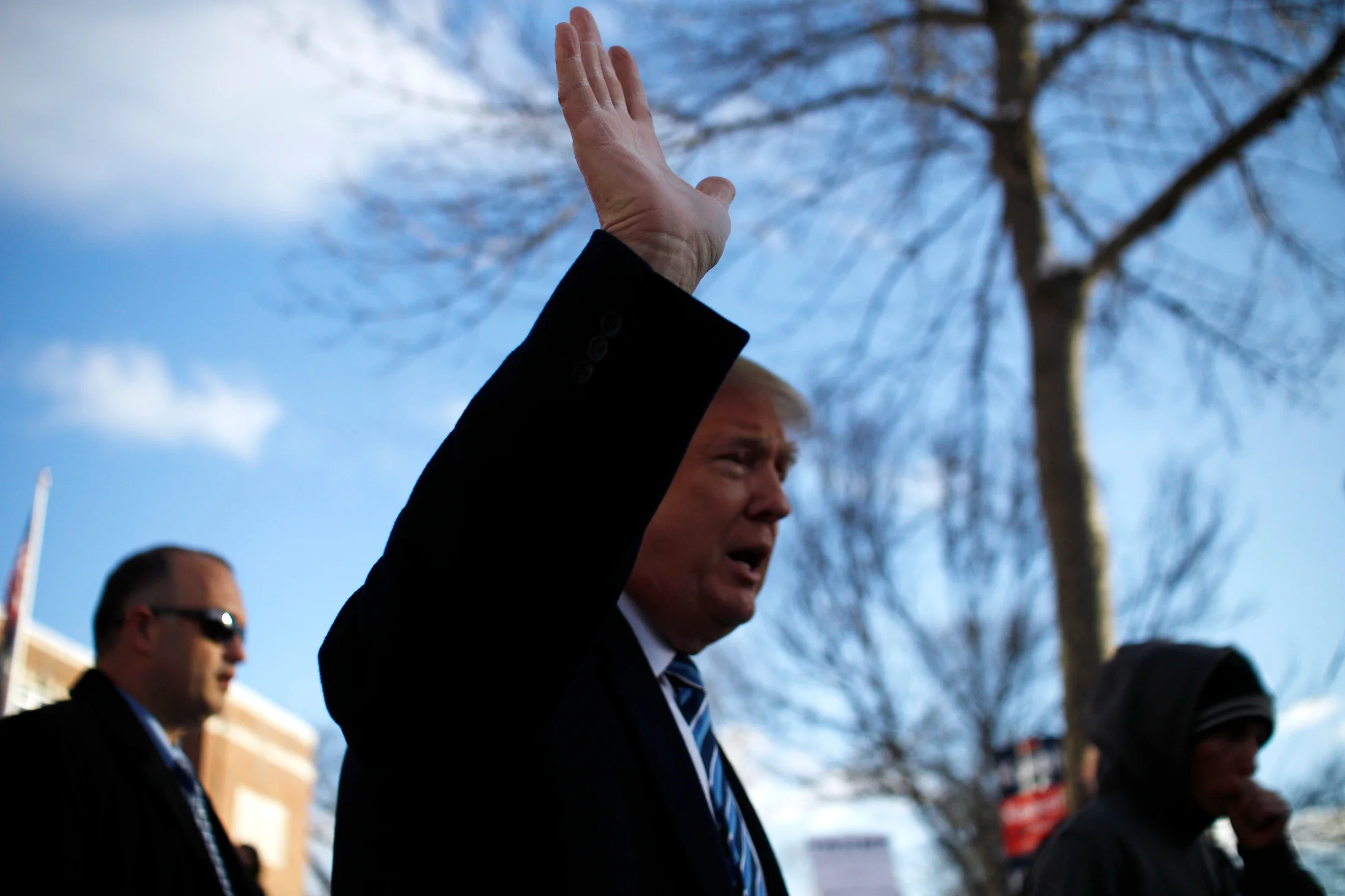 Republican presidential candidate Donald Trump waves to the crowd as he walks back to his motorcade after a visit to the primary polling station at the Webster Elementary School in Manchester, New Hampshire on February 9, 2016. The New Hampshire presidential primary is the first in the nation and is the culmination of months of campaigning by a large field of presidential candidates.