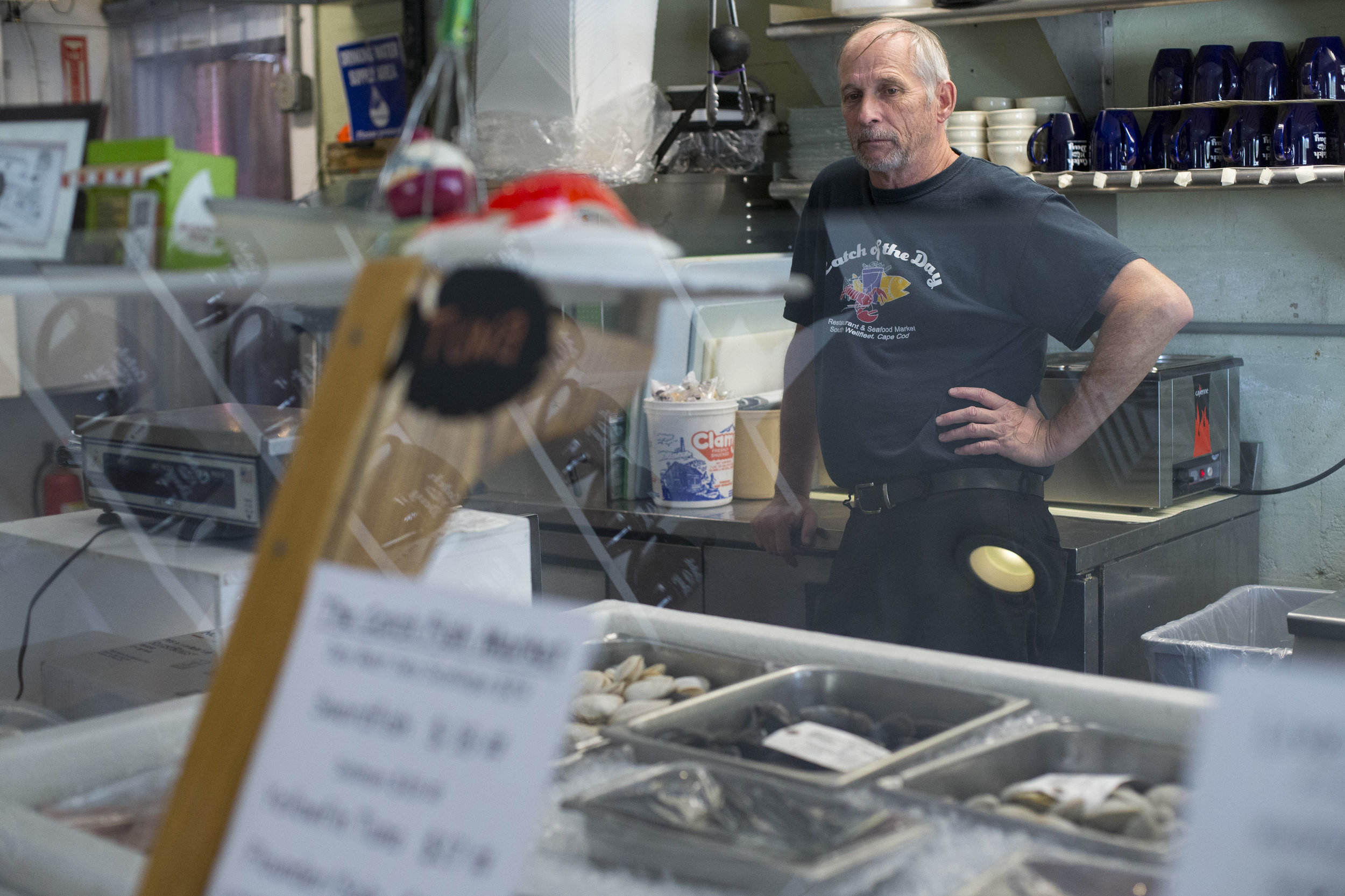  Chuck Fletcher, manager of Catch of the Day restaurant and seafood market, takes a quick break behind the counter of the seafood market in Wellfleet, Massachusetts on May 21, 2018. The business is one of many that are having difficulty finding seaso