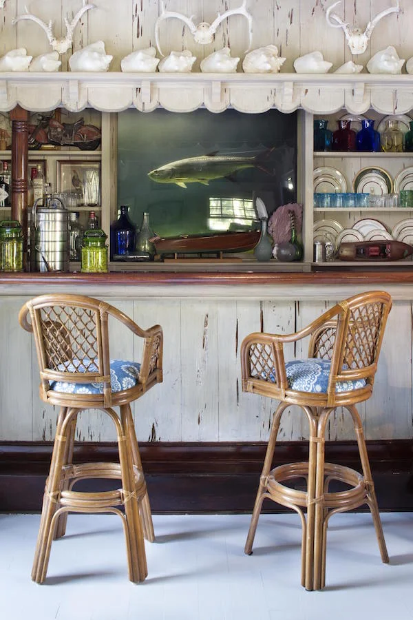 Lizzie Pulizer, daughter of Lilly, puts a bohemian spin on her mother's interior decorating aesthetic with rattan bar stools and a beachy distressed driftwood bar.