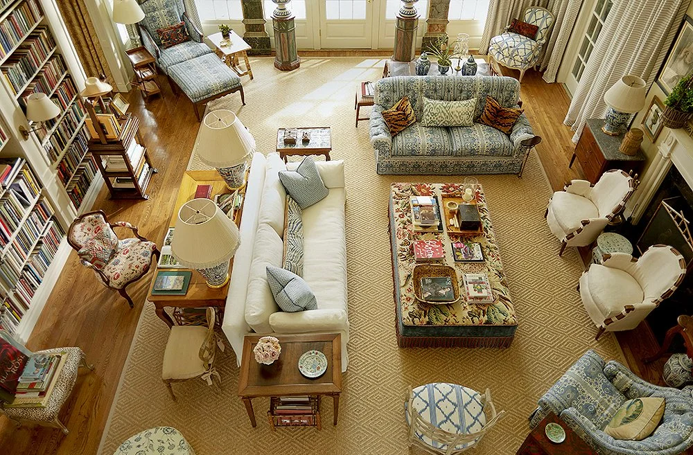 This classic diamond pattern sisal rug perfectly frames the eclectic mix of rich upholstery fabrics in this room. A livingroom will always look and feel more expansive if at the very minimum the front legs of seating are resting on the rug. Shown here are pieces sitting entirely on the rug while the armchairs by the fireplace just have the front legs resting on it - designer Charlotte Moss, p hotography Pieter Estersohn