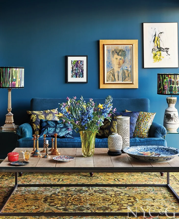 pillows designed by Mariska on the sofa in a mix of patterns play nicely with the intricately patterned area rug…varying gold tones not surprisingly, add warmth to the room