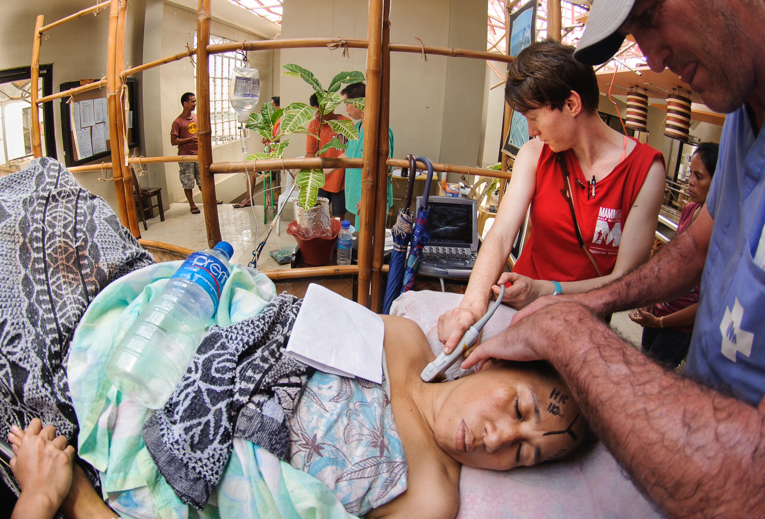 One of the first patients seen in clinic requires an emergency amputation of her right arm--team members use a battery-powered ultrasound machine to guide the injection of anesthetic into a collection of nerves, numbing the arm prior to surgery.