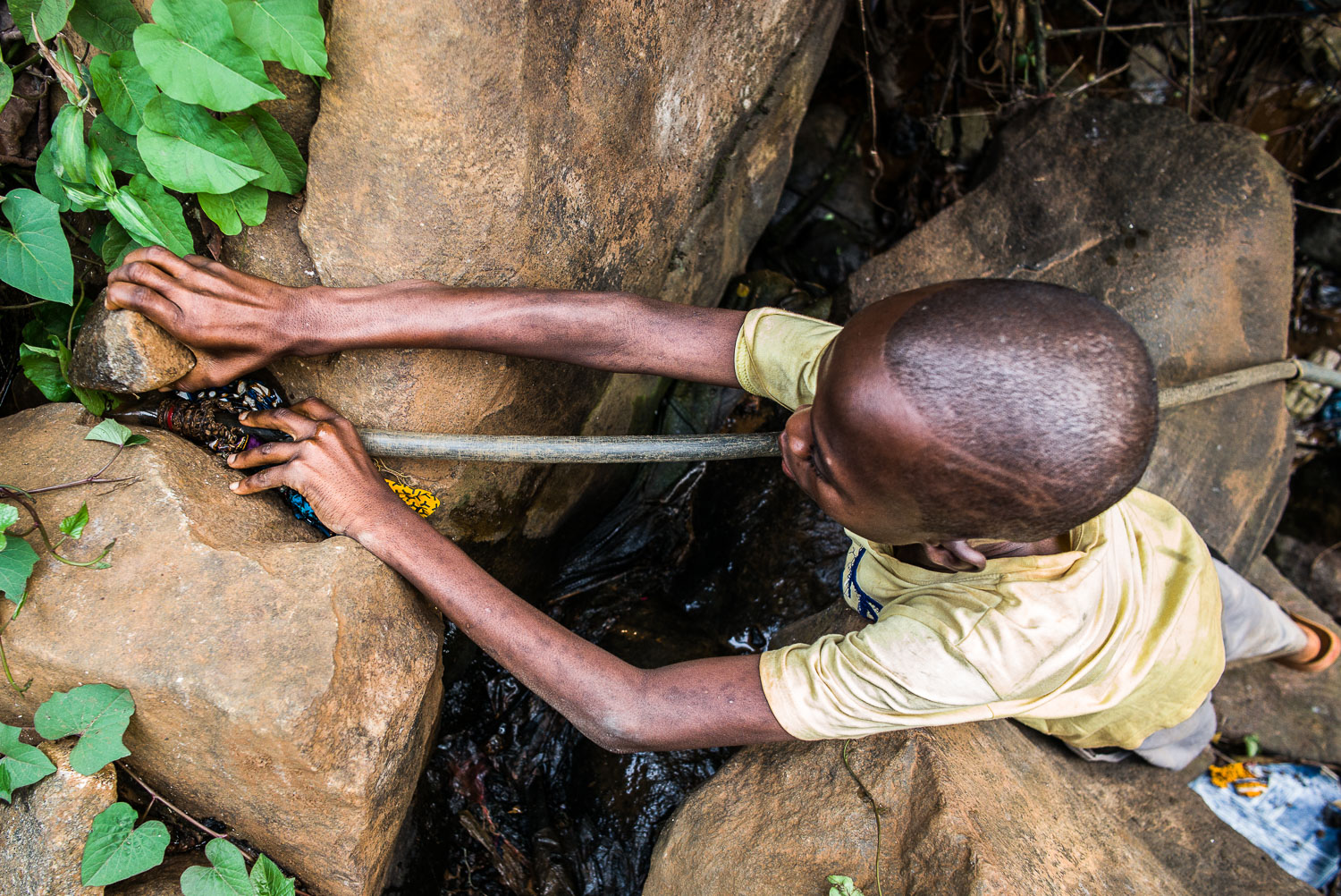April 2017. Francis fetches water at the same stream behind his home. Now, the stream is invisible to the naked eye, and Francis and his grandmother Nidia have fashioned a series of discarded plastic hoses into a collecting system to siphon water fr