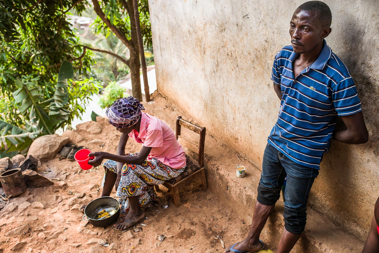 April 2017. Matthew looks on as his wife Eye tries to eat. Matthew lost his job during the economic downturn at the height of the Ebola crisis in early 2015, and has been unable to find stable employment since then.