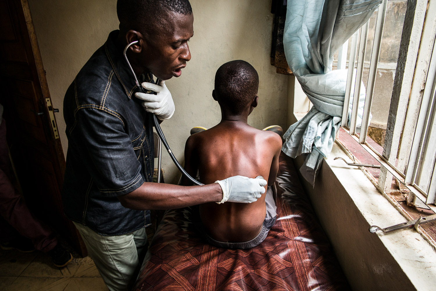 April 2017. Francis is evaluated by a medical technician at the local Al Farouk medical clinic. Over the past year, Francis has suffered worsening malnutrition and recurrent bouts of malaria and typhoid, which have also negatively impacted his abili