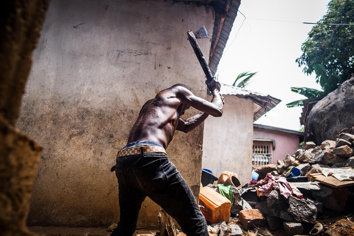 April 2017. Matthew Gbakie immerses himself in household chores to pass the time, here chopping wood to make kindling to use for cooking the evening meal.