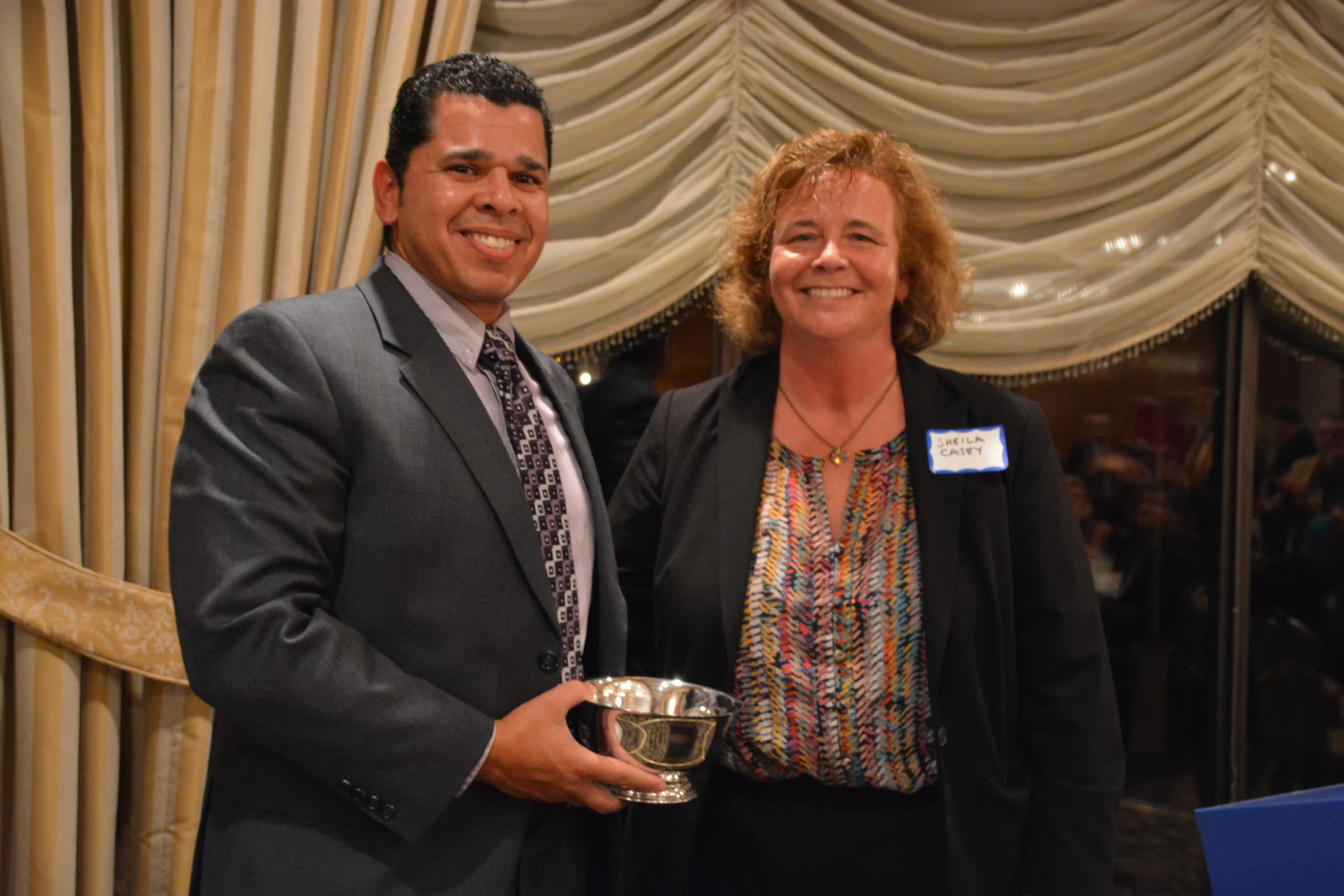 The LBA's Sheila Casey awarded this year's Liberty Bell Award to Juan Bonilla, Deputy Director of Lawrence Community Works