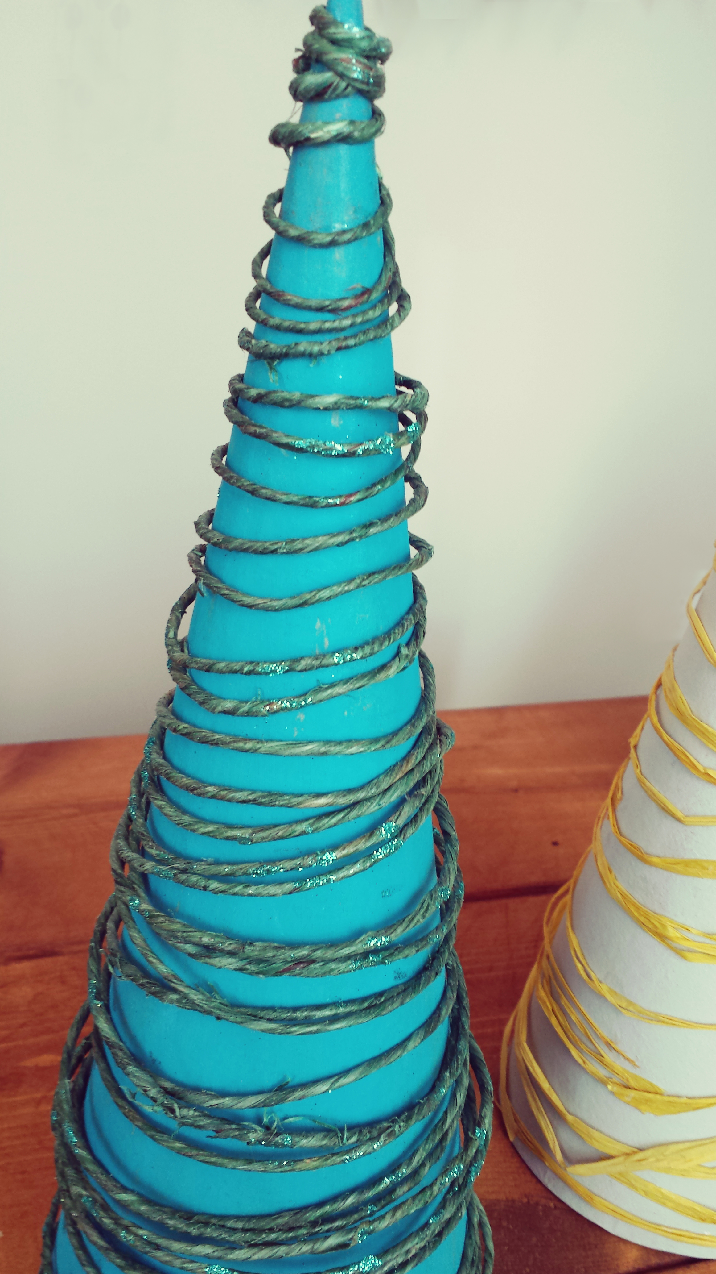 The wire may be a little tough at first but once you get the hang of it you will go fast. Once again, I painted the cone with the acrylic paint and let it dry. Take the wire and begin at the bottom. Began to wrap the wired around the cone adjusted the width as needed. Once you've gotten to the top, glue the bottom tip of the wire to the cone. Use a strong glue. It may take a little bit to dry then glue the ending tip at the top. Again, it doesn't have to be symmetrically perfect. In my opinion, it's better when it's not! 