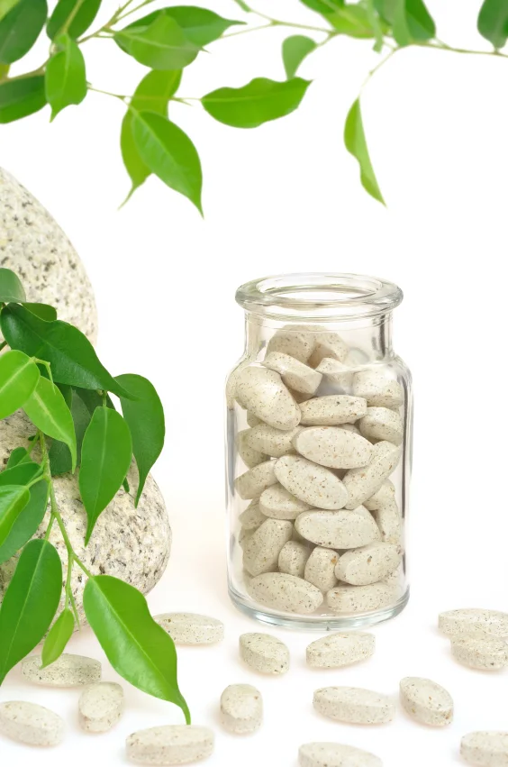 Compléments alimentaire naturels dans un flacon en verre entouré de plante verte