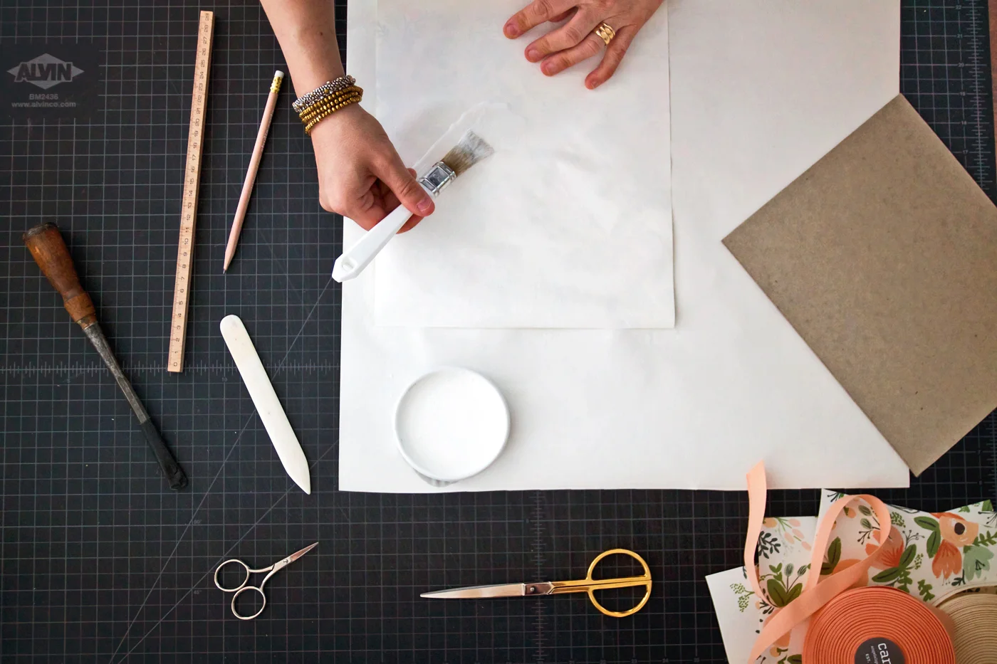 Step 2: Working quickly brush the glue onto the back of your paper. Then transfer your cardboard to the center and press down, working out any air bubbles with your hands or bone folder.