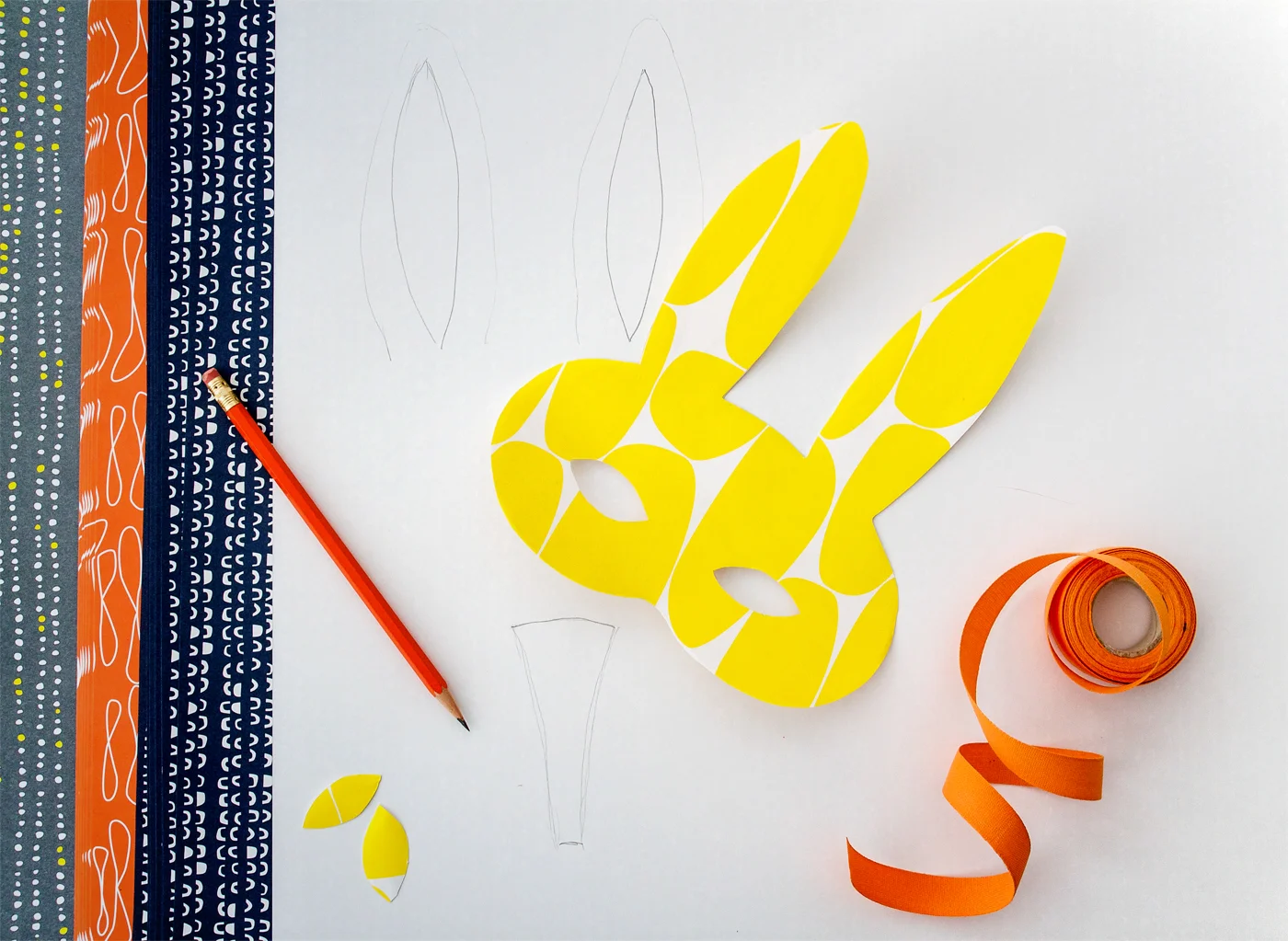 Step 4: Choose another piece of paper for your accents. Using the edges of your mask as a template, draw these details onto the back of your second piece of paper. Cut these out.