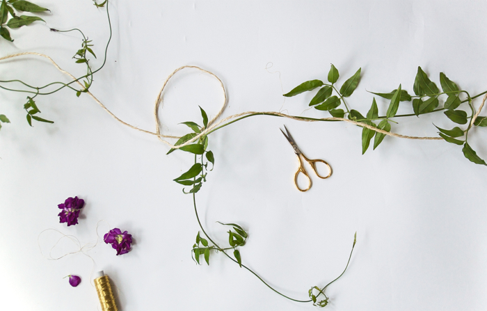 Step 1: Cut you twine to the desired length. Then loosely wind you vine around the twine. For a more whimsical and romantic quality, drape the ends of your vine.