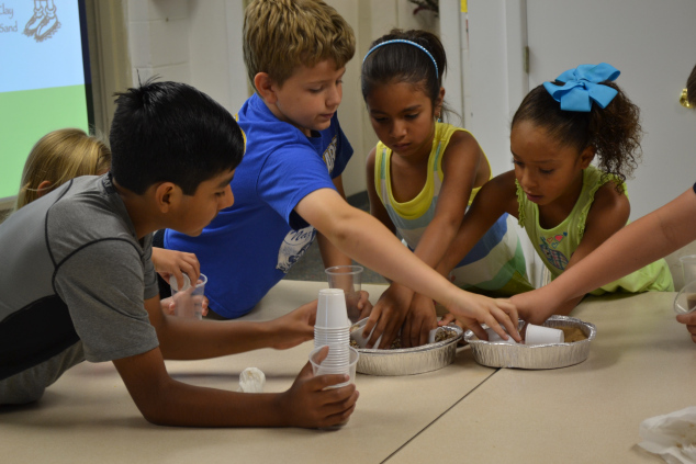 Filling cups with sand and gravel for mini aquifers.