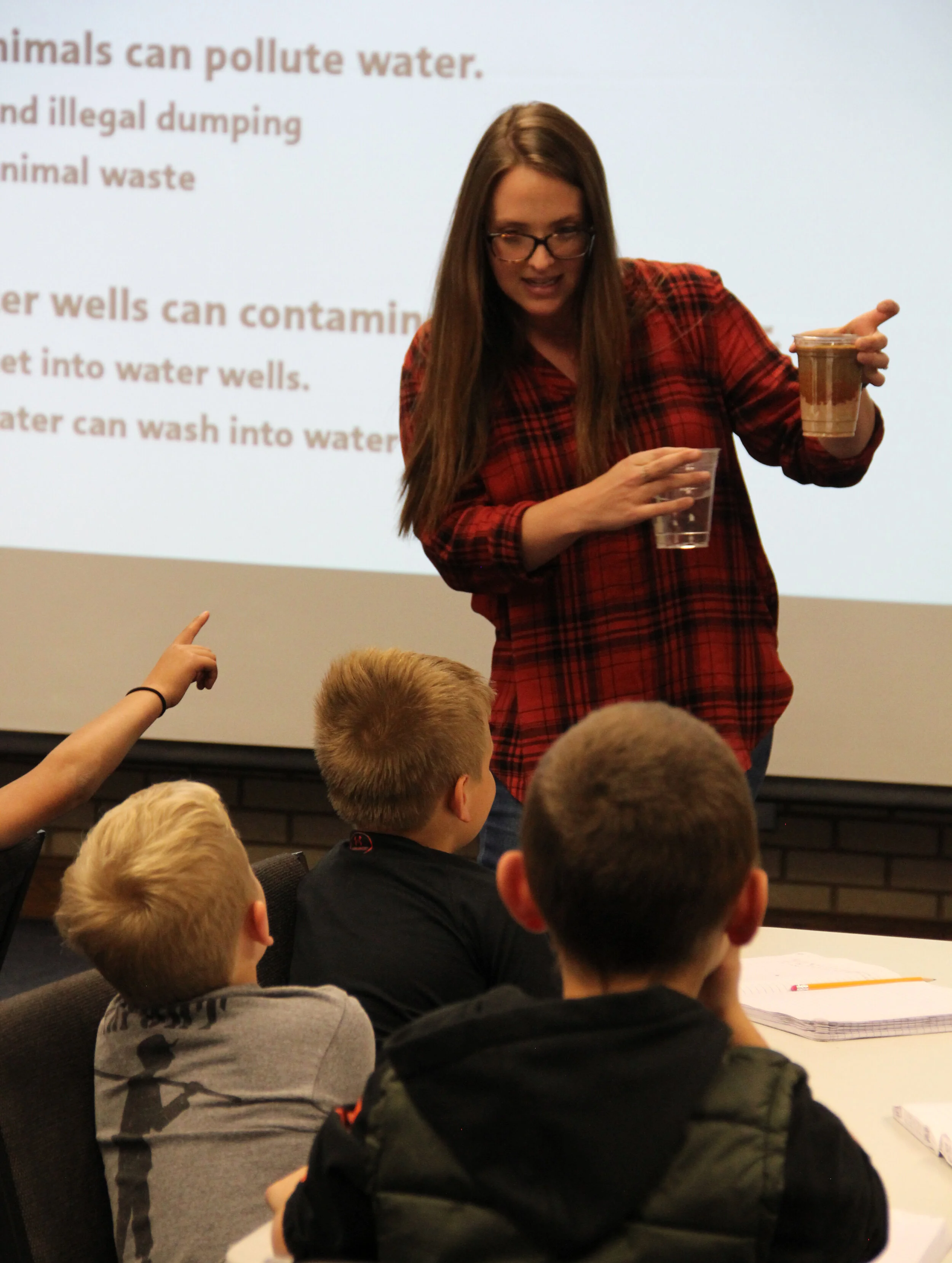 HPWD Education and Outreach Coordinator Katherine Drury uses a "mini aquifer" to demonstrate groundwater contamination to elementary school students from Slaton. The students and their teacher visited the HPWD office during an Oct. 23 field trip to the HPWD office.
