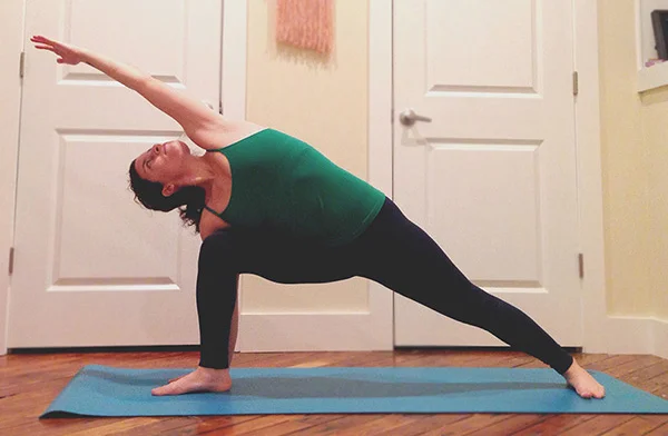 Extended Side Angle is a nice transition after Triangle Pose because the entrance into it is similar. -Standing at the front of your mat, inhale and take a bigger step (about one of your leg's distance) towards the back of your mat with your right foot, arms raised parallel to the ground. -Exhale bend your right knee so that it is directly over your right ankle and your leg is at a 90º angle. Plant your right hand on the outside of your right foot and inhale your left arm up and over reaching overhead. Gaze is at your left elbow. You should feel a nice stretch all along your left ribs and in the side of your body here. -Make sure you are pressing your right knee into your right arm so that your hips don't fall inward, and keep that left leg strong! -Stay here for 5 breaths then switch to the other side.
