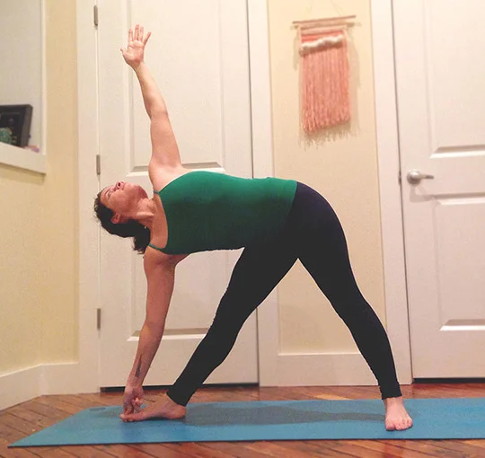 This pose can be challenging, but give it a try because it really opens up the chest and creates space in the front of your body while strengthening your back. -From a standing position at the front of your mat, raise your hands parallel to the ground, take an inhale and step your right foot towards the back of your mat. Left toes are pointing towards the side of your mat. Make sure your right heel is in line with your left heel here. -Keeping both legs straight, on an exhale lean out over your right leg and reach for your big toe (or shin or ankle if you can't reach your toe). -In this case, I grabbed my big toe. Once you grab hold of whatever you chose, inhale and reach your left hand up, arch your back slightly so that your chest is opening to the side and torso is parallel to the ground. Both legs are strong here (make sure your knees are not locked!) and your core is engaged to keep you stable. -If it feels comfortable, gaze up at your left finger tips without straining your neck, and stay here for 5 breaths then switch to the other side.