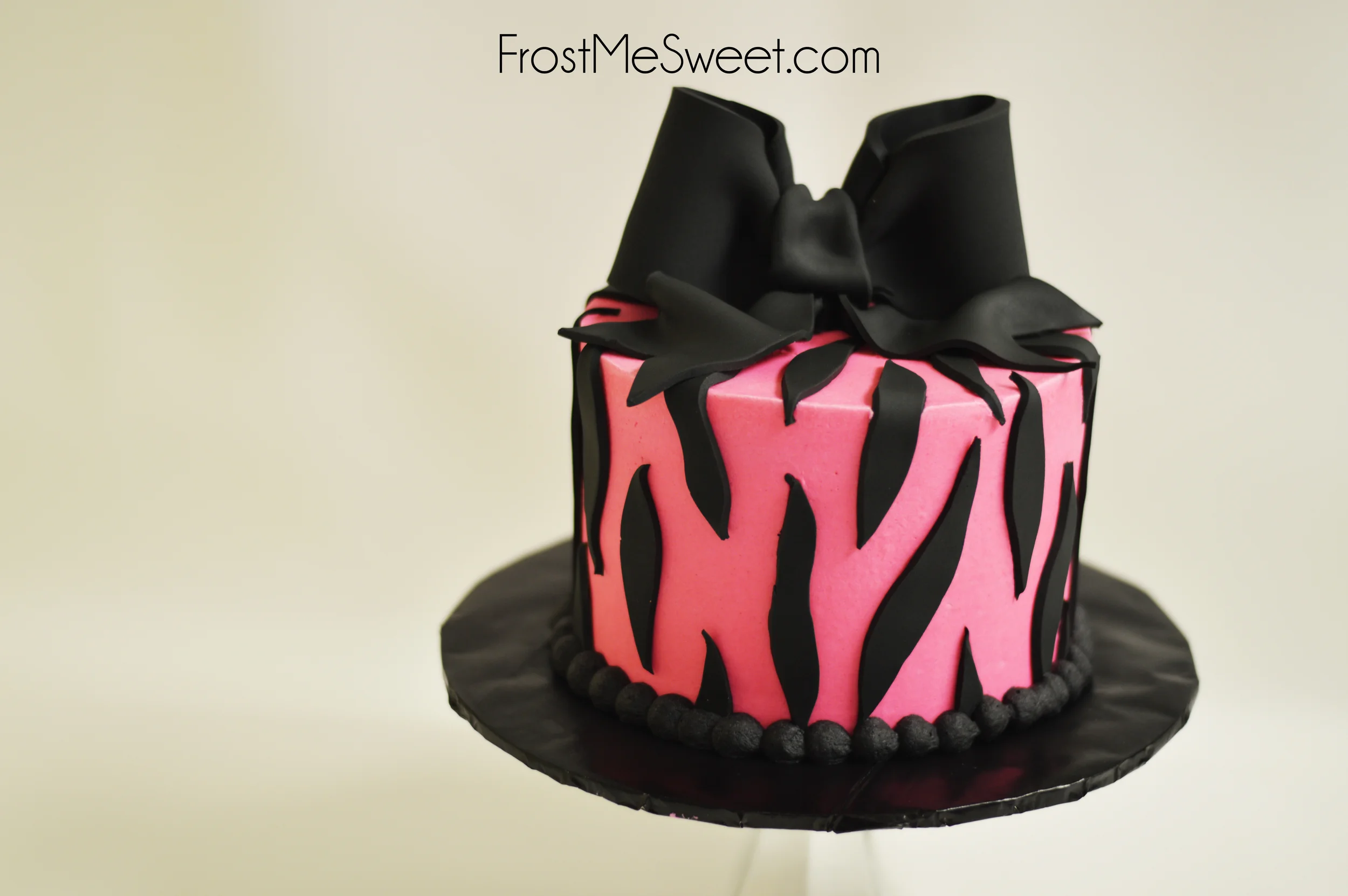 Pink and black zebra print cake with bow