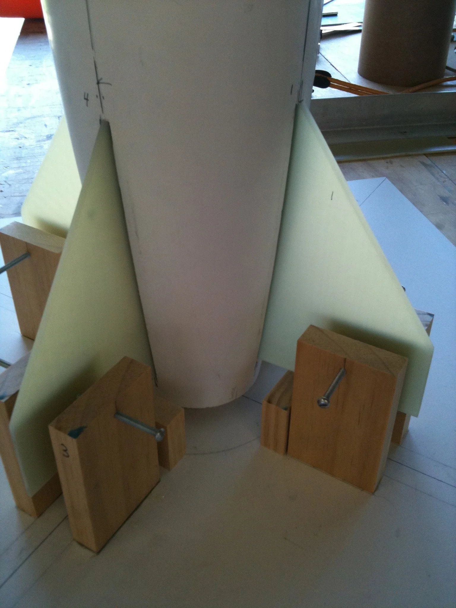 A fin positioning rig is used to ensure that the fins are perpendicular to each other. Small adjustments in the bolts that clamp onto the fins are made to ensure alignment. 