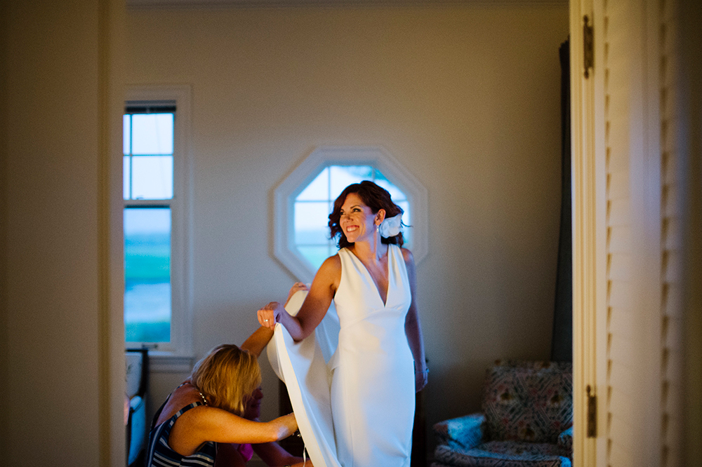 Bride getting her dress bustled after private outdoor ceremony