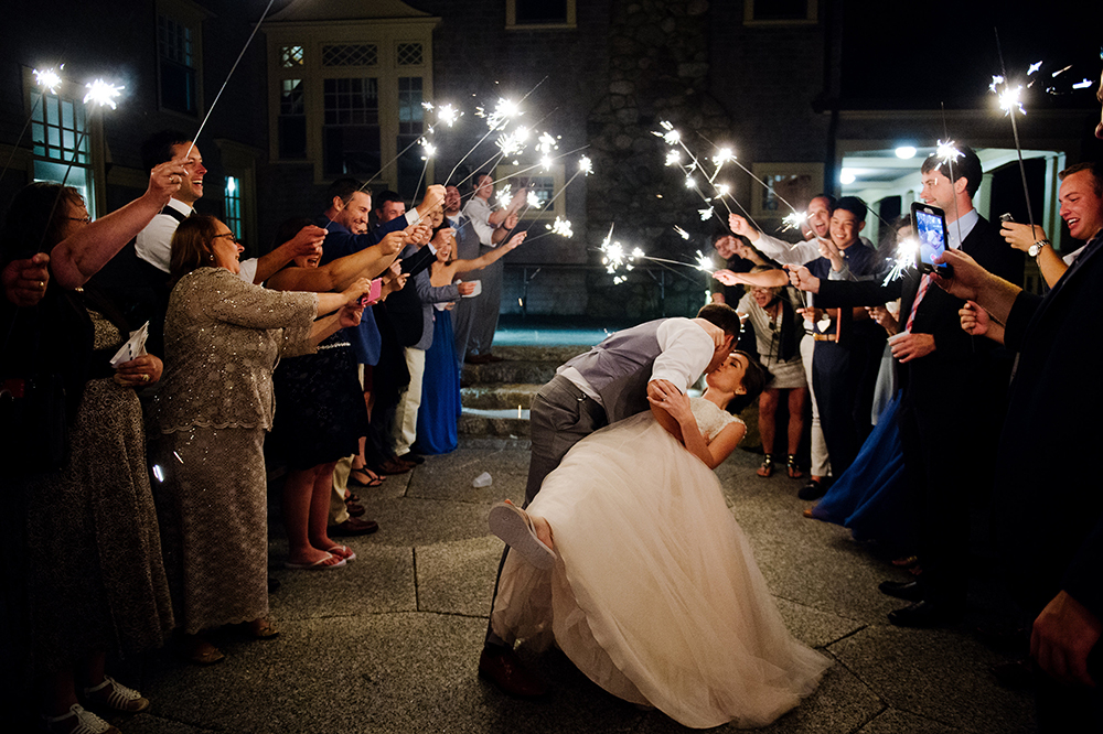 Groom dips bride during sparkler exit