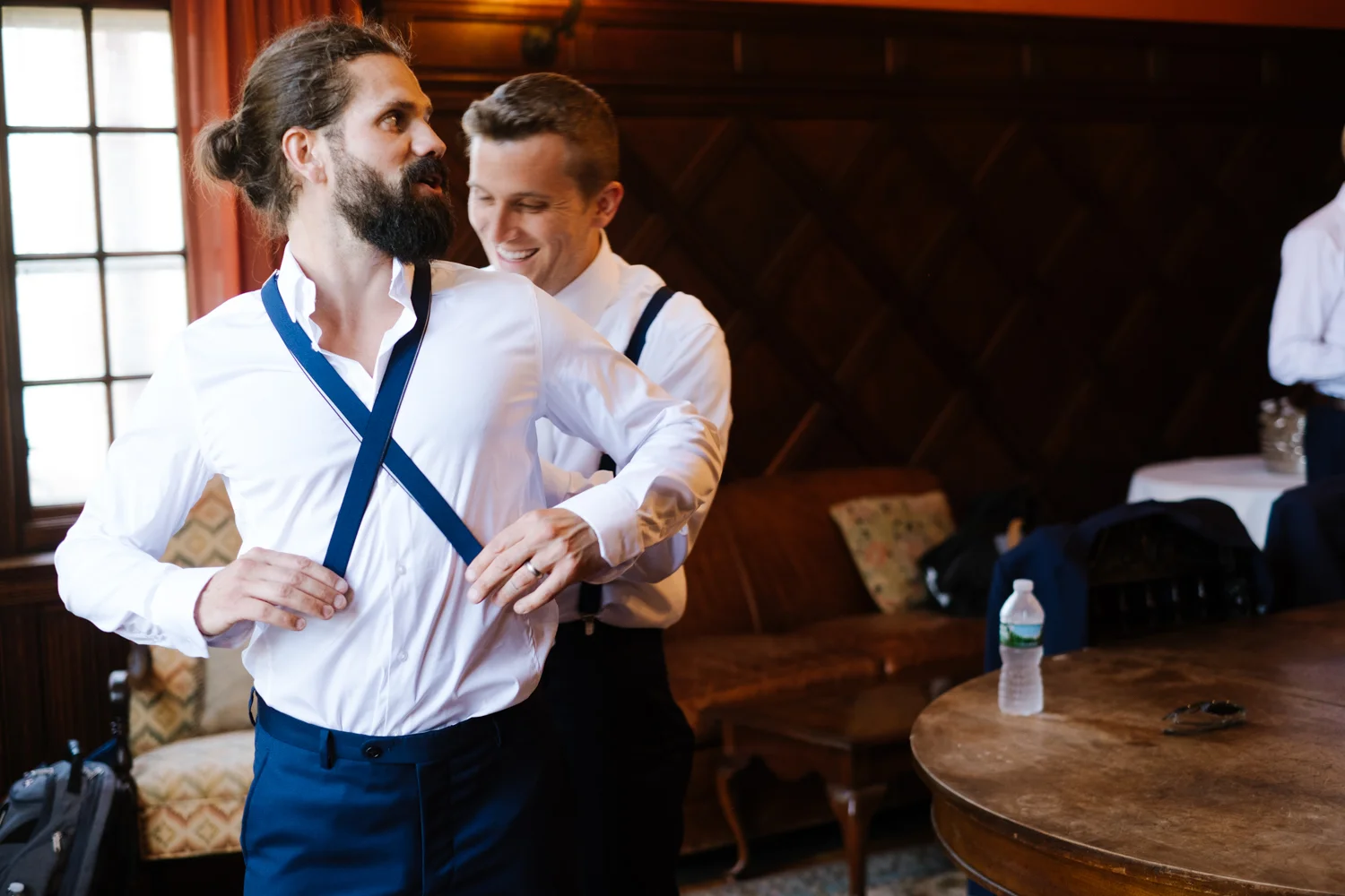 Groomsmen put suspenders on