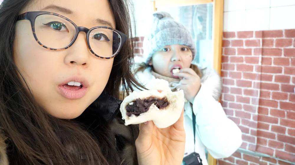 Showing you how thick the exterior skin is. Compared to the previous shop we visited (the one with the grandma painted on the wall), the buns here have more red bean filling and thinner skin. More tasty this way!