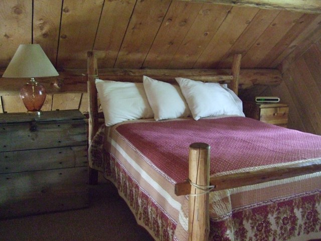 The hand-hewn log bed in the loft.