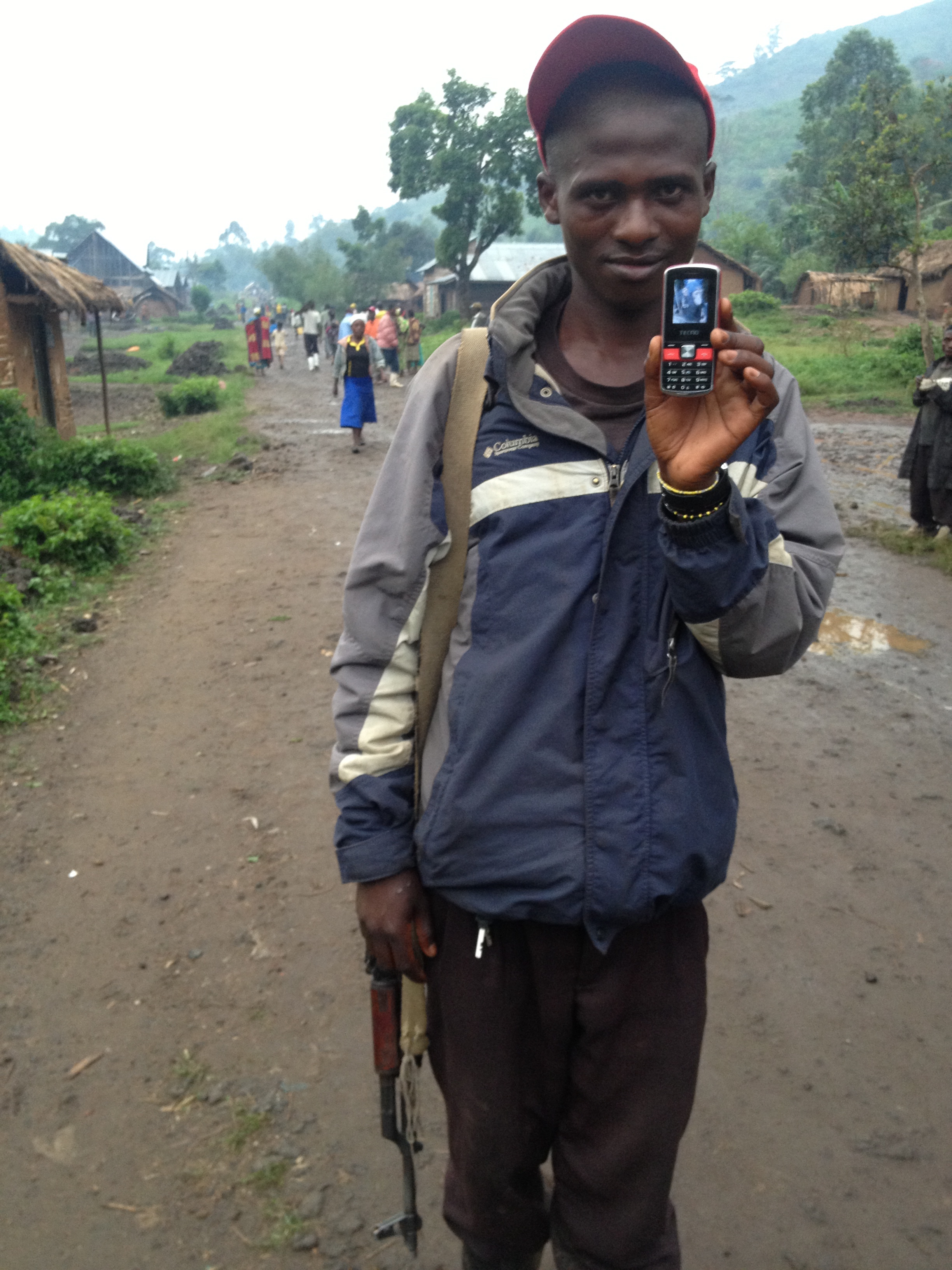 This young boy holds his gun and a photo of a chimpanzee he wants me to buy from him. The bizarre moments in life…