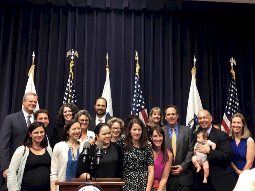 Charles Glick, along with advocates and legislators stand with Governor Charlie Baker after he signs the Pregnant Workers Fairness Act in July 2017.