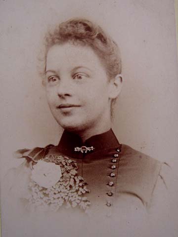 Alluring Victorian lady with a horseshoe brooch pin adorning her collar. 