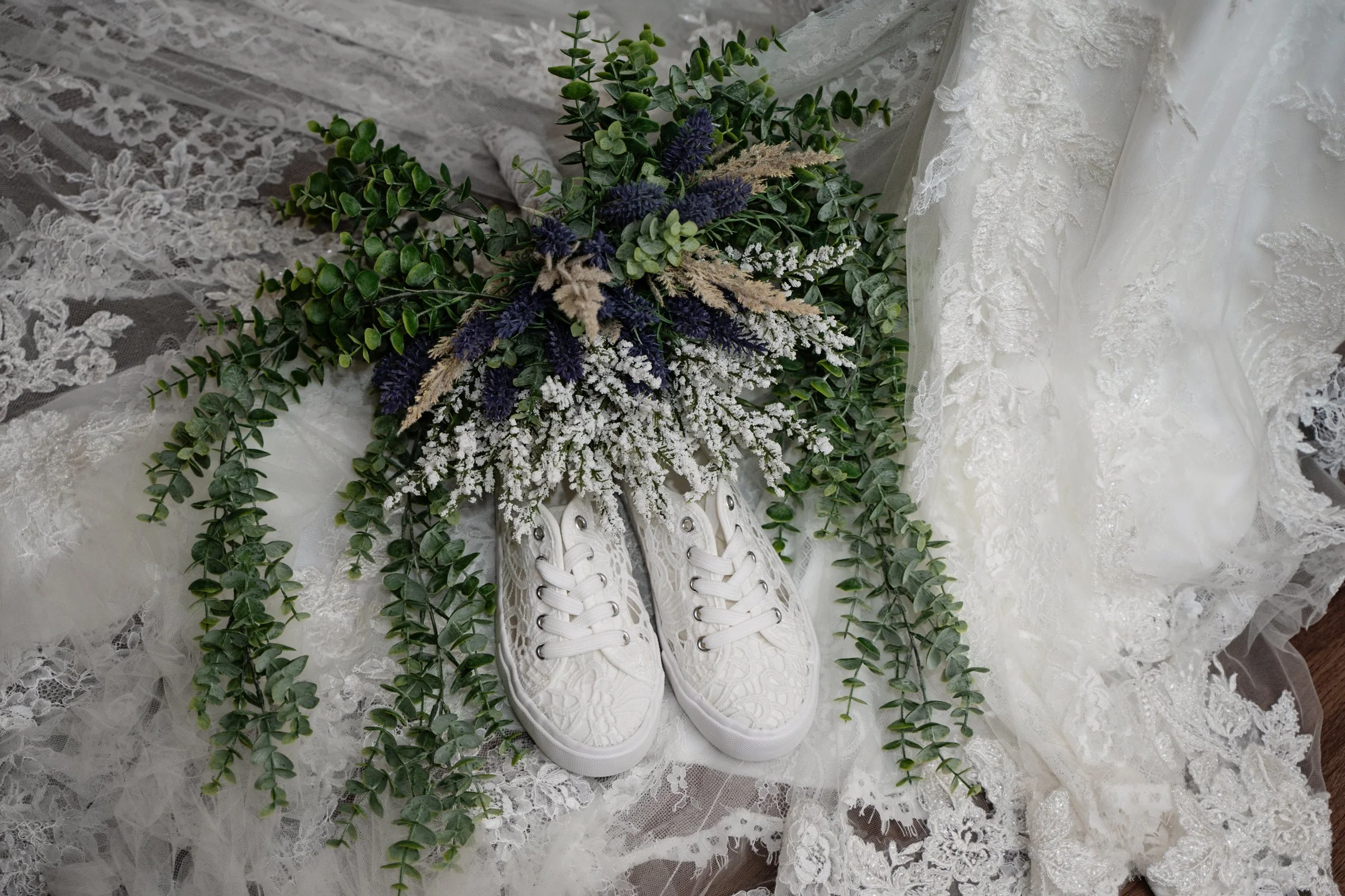 The bride's white shoes and lavendar bouquet