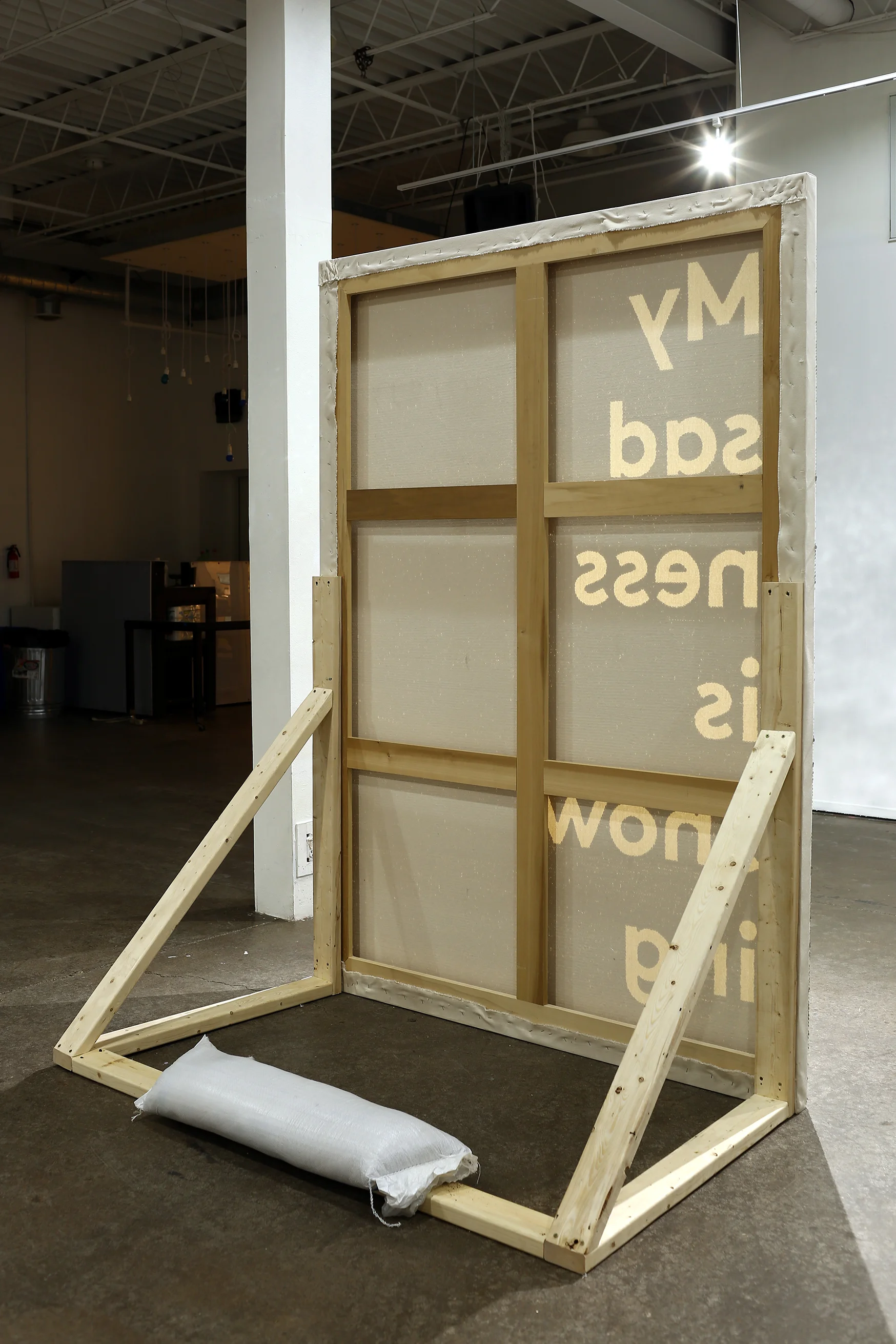 My sadness is showing (reverse install shot) Sequin, embroidery thread on canvas, wooden supports, sandbags 60” x 84” x 35.5” 2016-2018