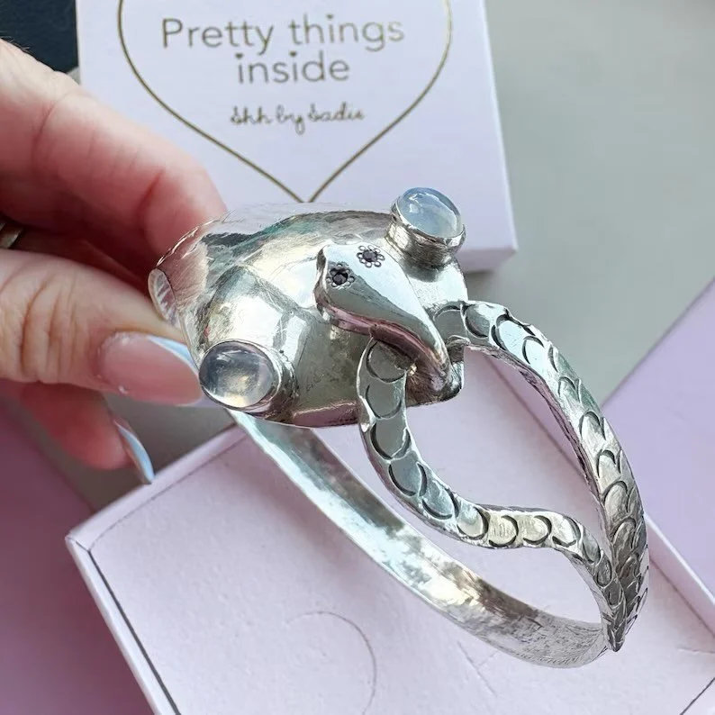 [SOLD] A love of snake jewellery is for life, not just for Christmas 😙 This is an intricately detailed sterling silver snake bangle with two snake heads. One has large moonstone eyes, the other has tiny ruby eyes. It&rsquo;s off to its new home 🐍
