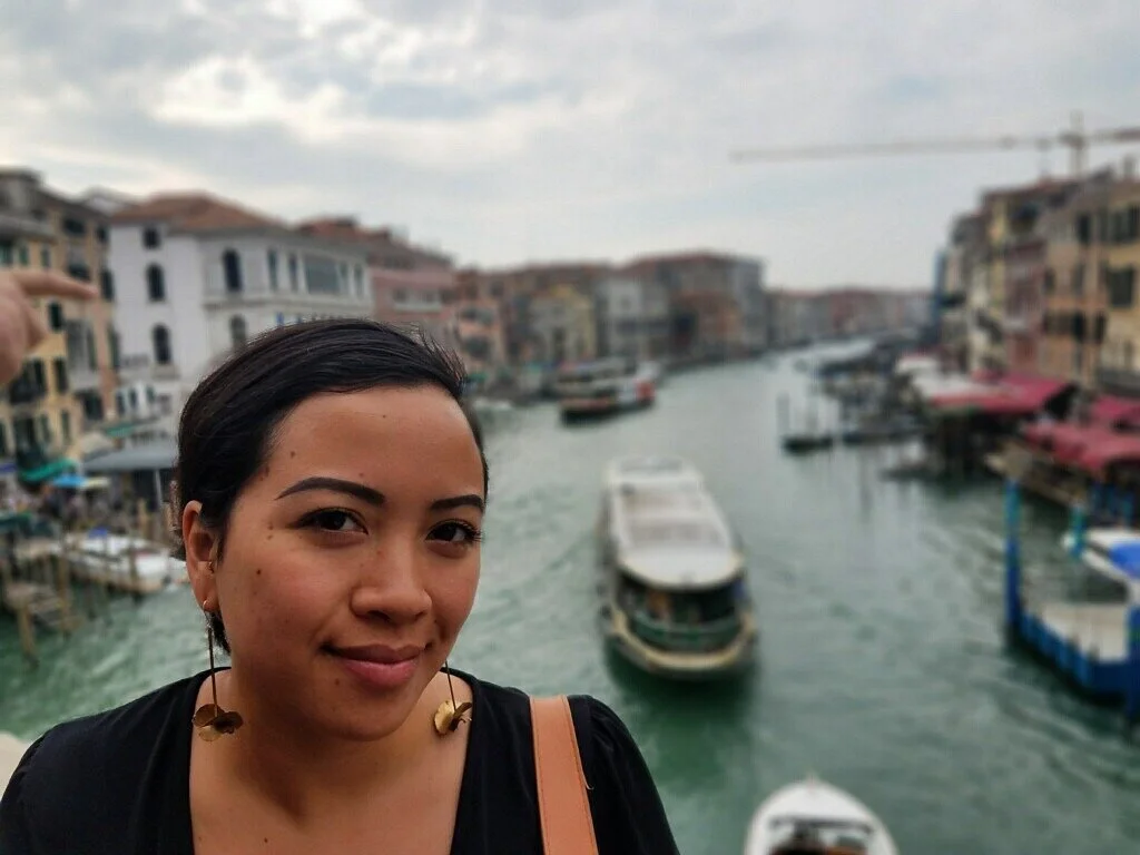 woman modelling bronze dangling petal earrings in venice italy