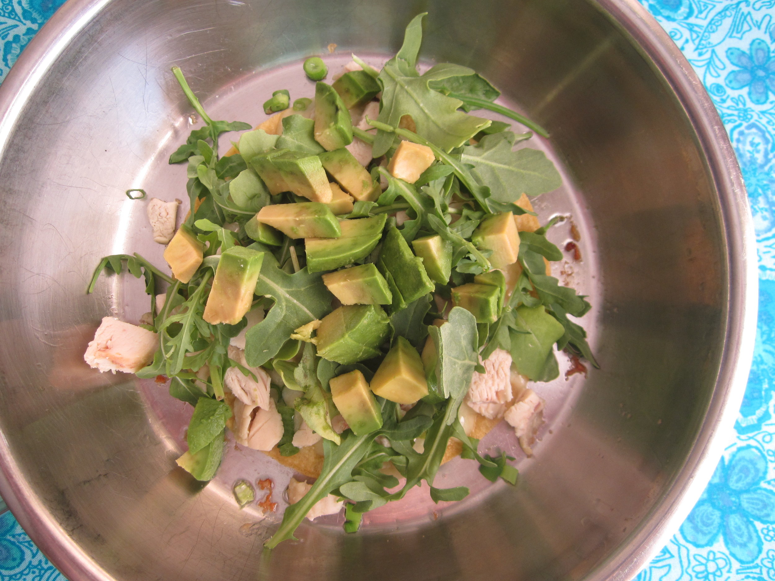 The second tortilla is filled with cheese, chicken, and arugula is now ready for the stovetop. Turn the first tortilla upside down as the "lid" for the quesadilla and heat through.