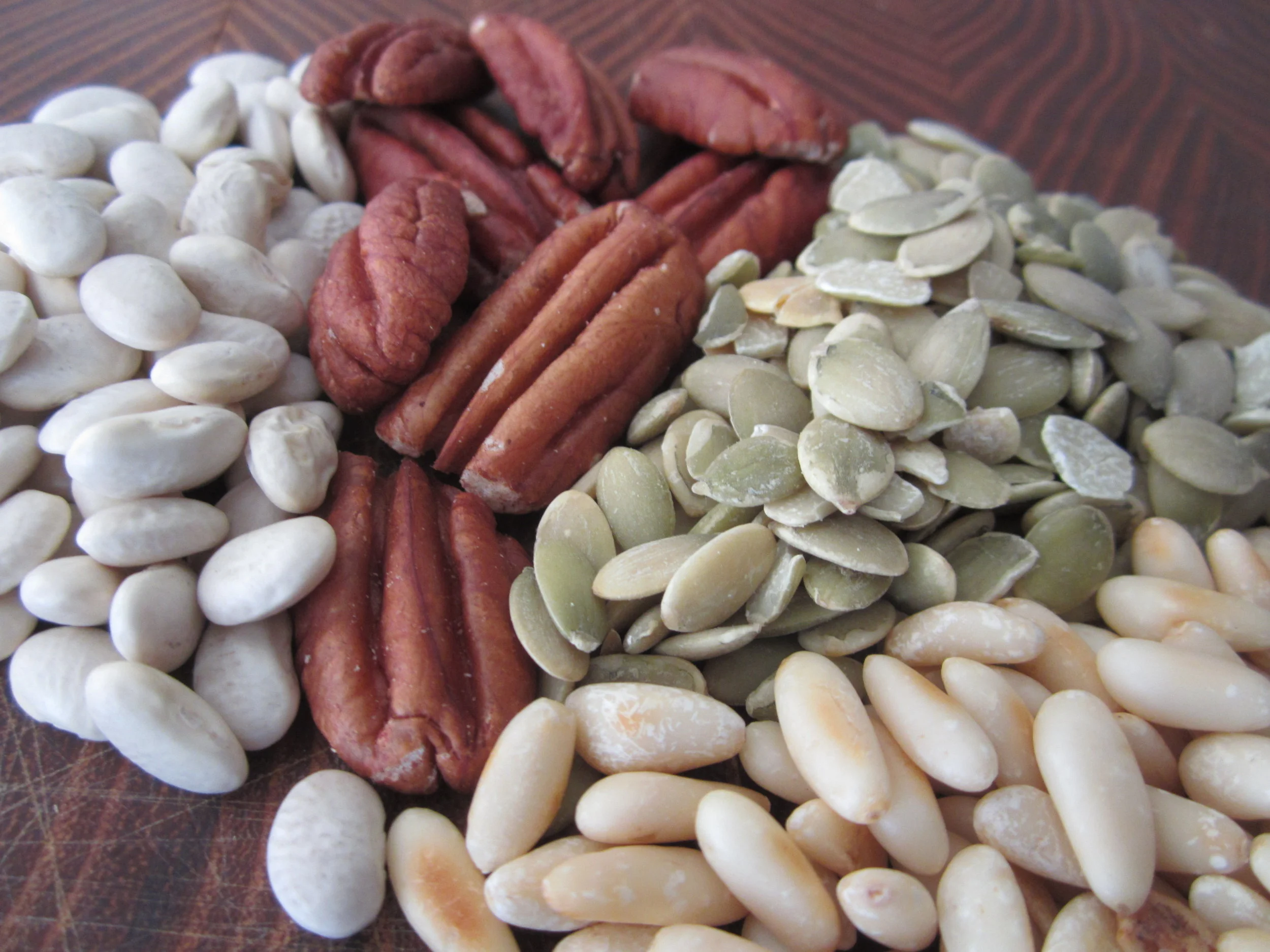Fiber sources are not all the same for people with IBD. Navy beans (left) are apt to cause trouble, while small portions of pecans, pepitas and pine nuts, which are lower in FODMAPs, may be tolerated more easily.