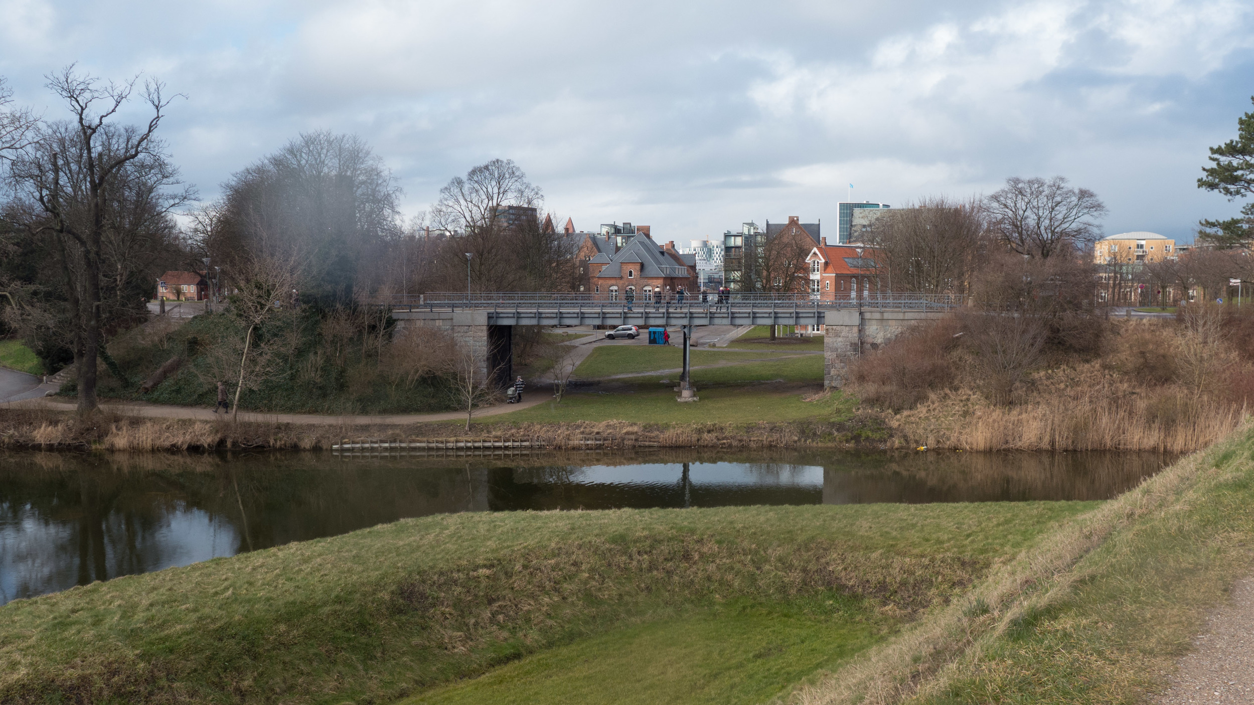 View from the embankment looking north along the route of the railway that went over the moat here and under the road bridge before continuing on to the Free Port beyond