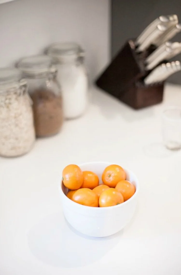 Jars and fresh oranges on a kitchen counter