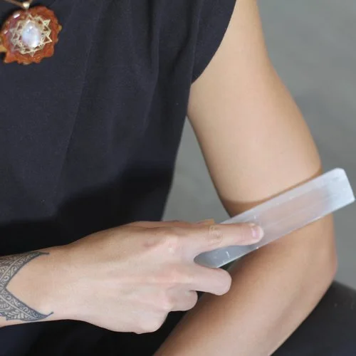 A selenite wand held along the arm