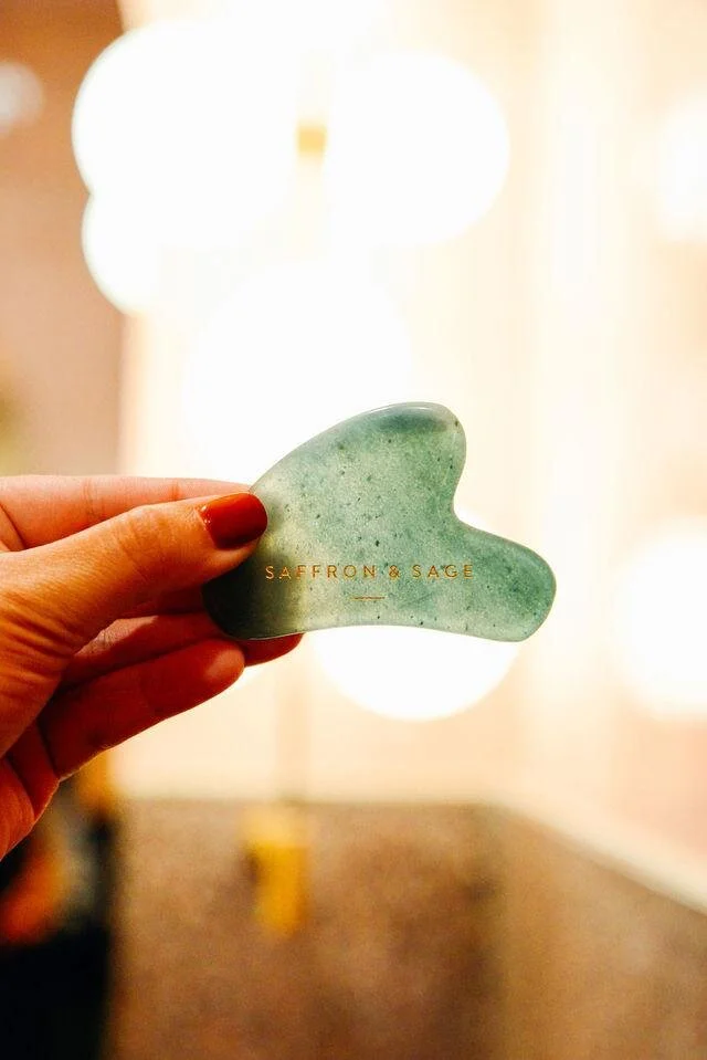 A gua sha stone held up to the light