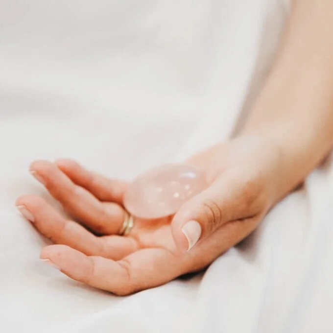 An open hand holding a small crystal