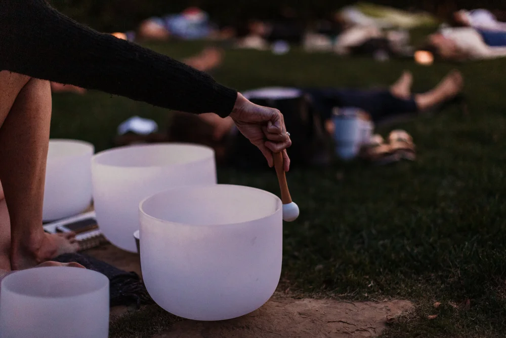 Hands playing a crystal singing bowl