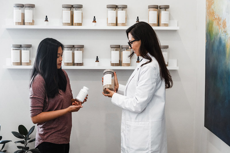 A Saffron & Sage doctor and patient choosing botanical remedies in the San Diego dispensary