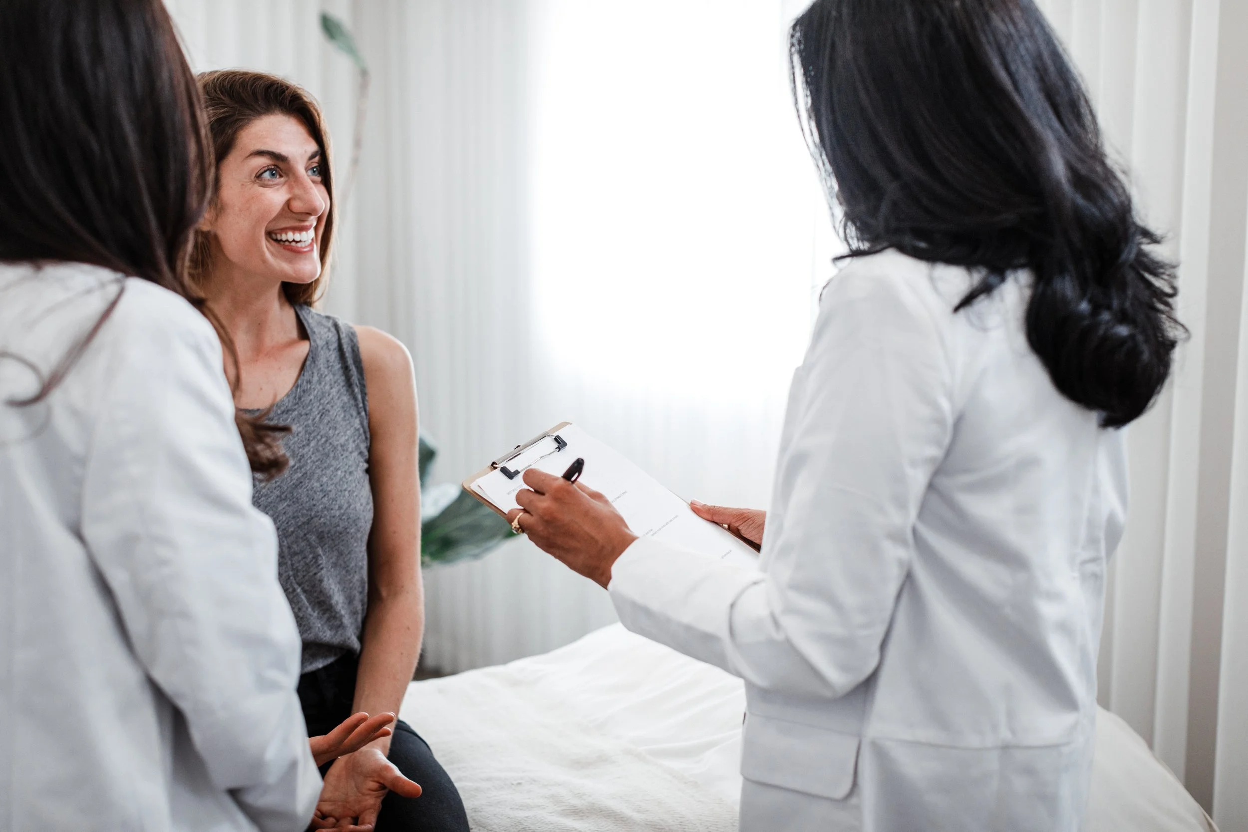 A Saffron & Sage doctor laughing with a client during a consultation