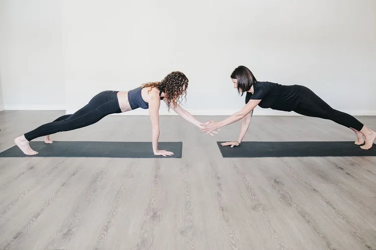 Two people holding a plank
